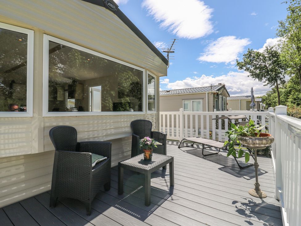 An outdoor deck with chairs and a table at Forest Retreat - FO26 Saxmundham