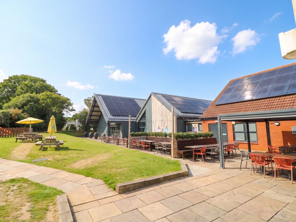 An outdoor area with picnic tables and buildings at Forest Retreat - FO26 in Saxmundham
