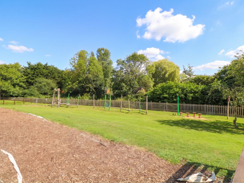 An outdoor area with playground equipment and grass at Forest Retreat - FO26 in Saxmundham