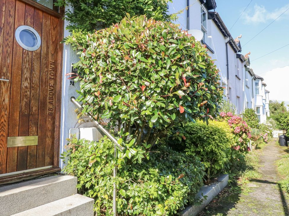 A front view of a house with a wooden door and shrubs at Dart Views in Dartmouth