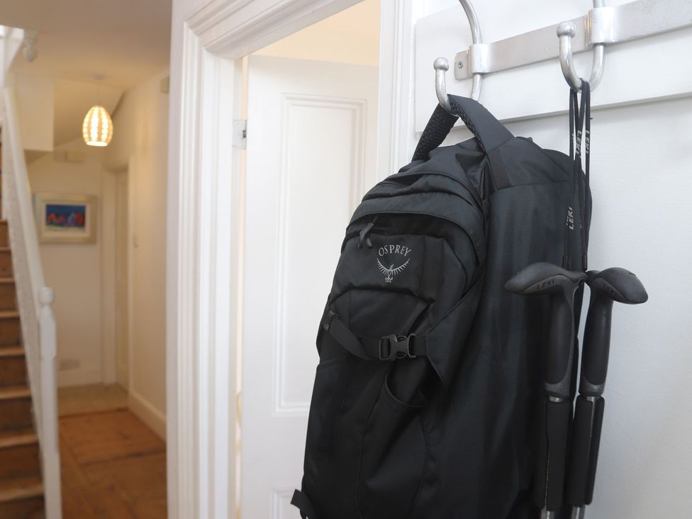 A hallway with a backpack and walking poles on a hook at Dart Views in Dartmouth