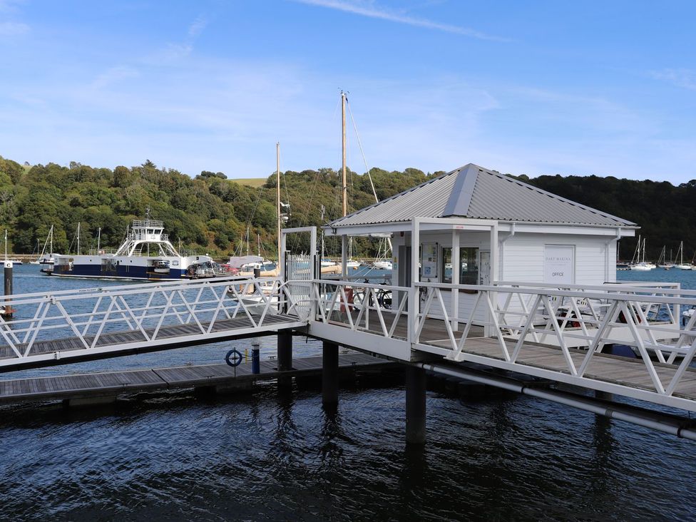 A dock with a boathouse and boats in the water at Dart Views in Dartmouth
