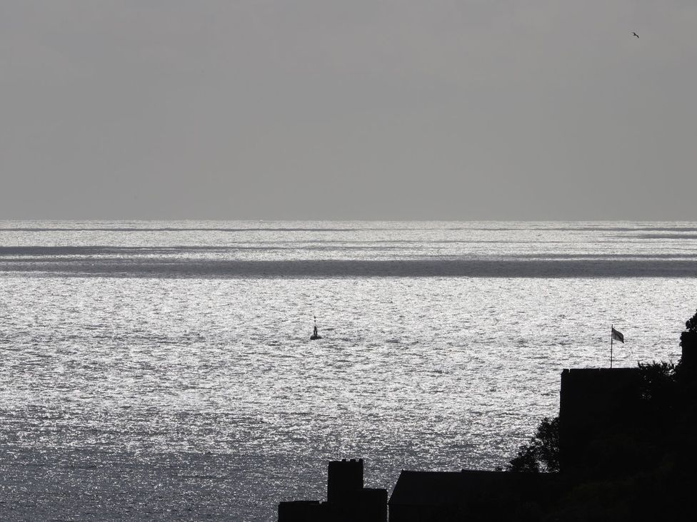 A view of the sea with a sailboat and buildings at Dart Views in Dartmouth