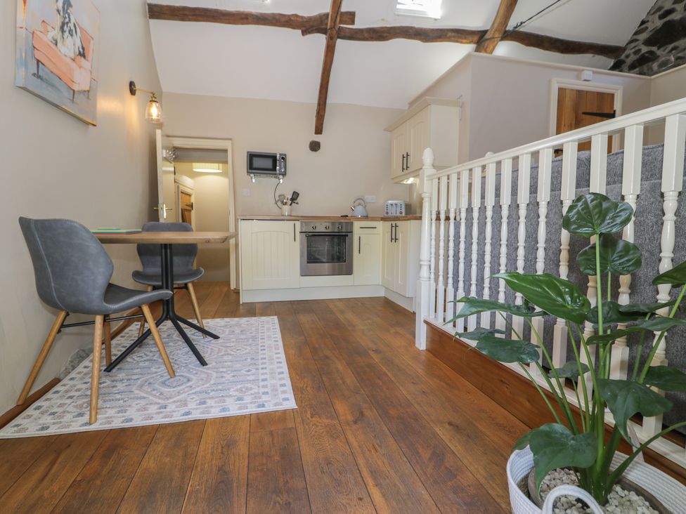 A kitchen with a table and chairs at Beudy Bach Llanbedr