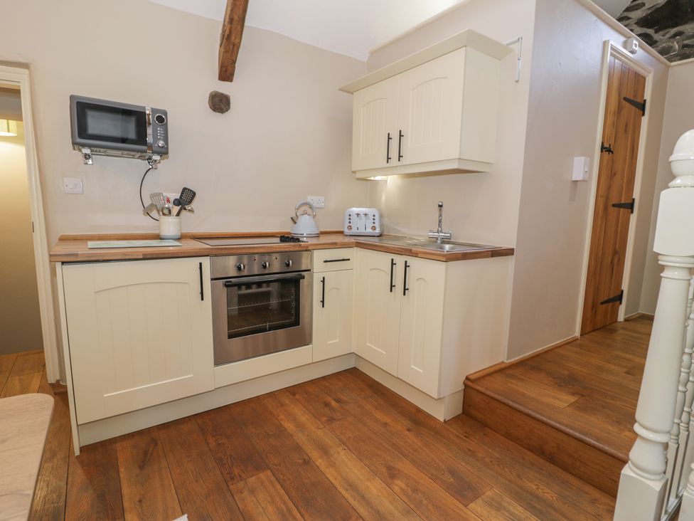 A kitchen with cabinets and appliances at Beudy Bach in Llanbedr