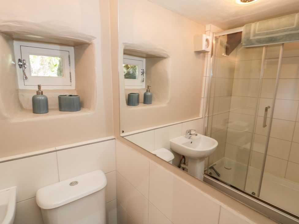 A bathroom with a sink, toilet, and shower at Beudy Bach Llanbedr