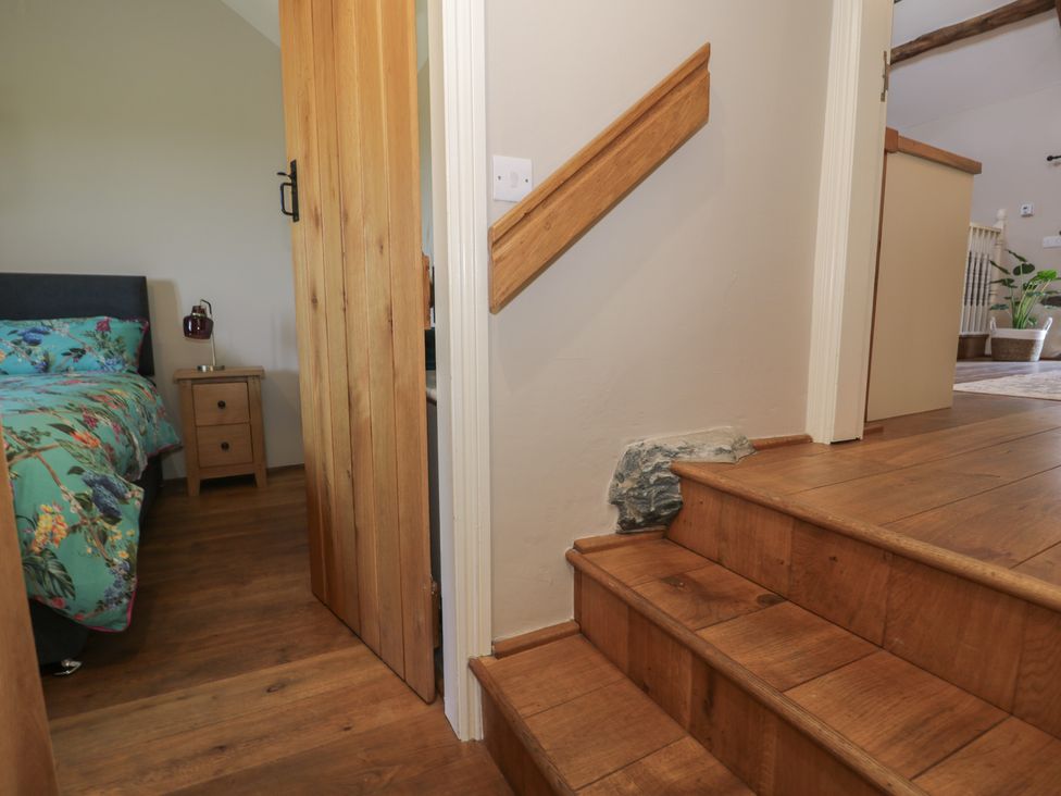 A bedroom with a bed and nightstand at Beudy Bach in Llanbedr