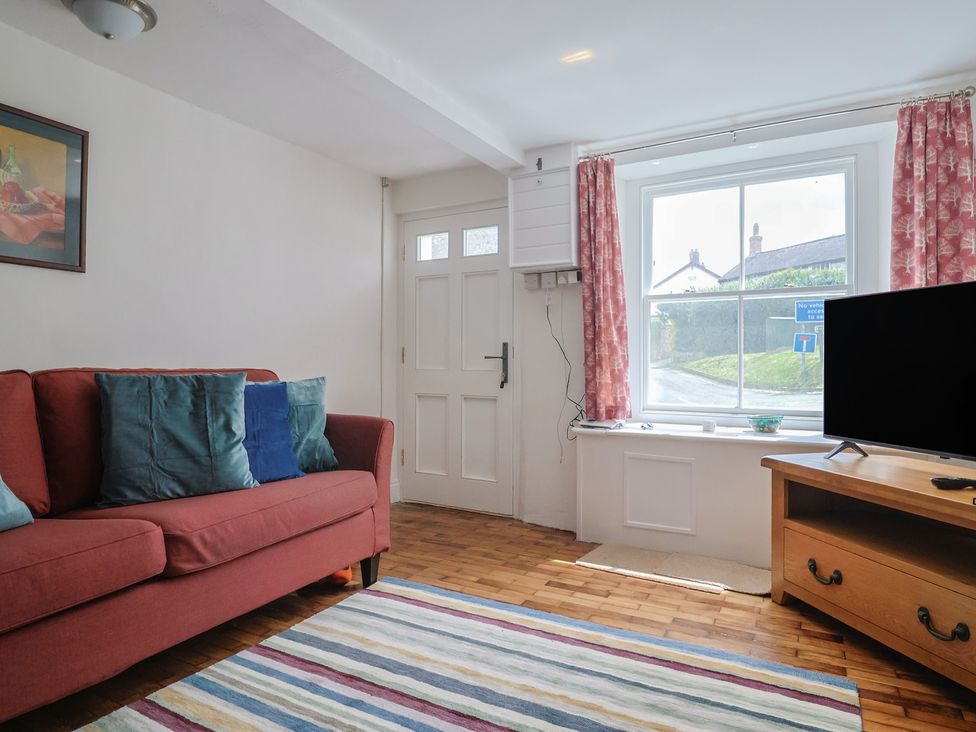 A living room with a sofa and television at Saybrook Cottage in Charmouth