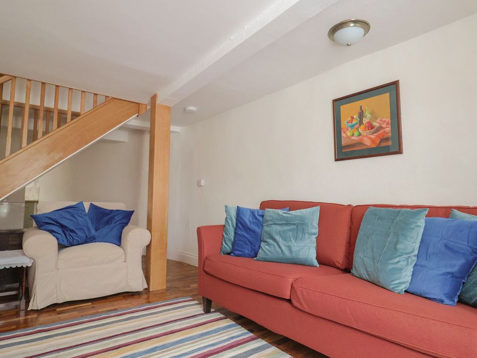 A living room with a sofa and armchair at Saybrook Cottage in Charmouth