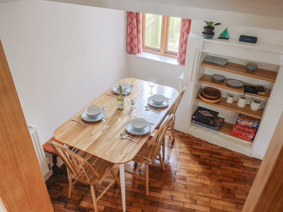 A dining room with a table set for meals at Saybrook Cottage in Charmouth