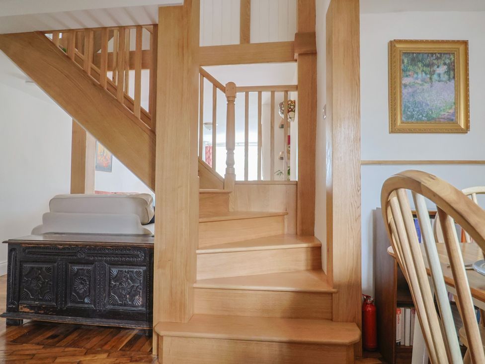 A staircase with wooden railing at Saybrook Cottage in Charmouth
