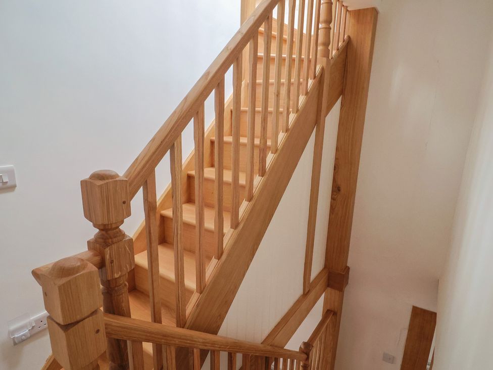 A staircase with wooden handrails at Saybrook Cottage in Charmouth