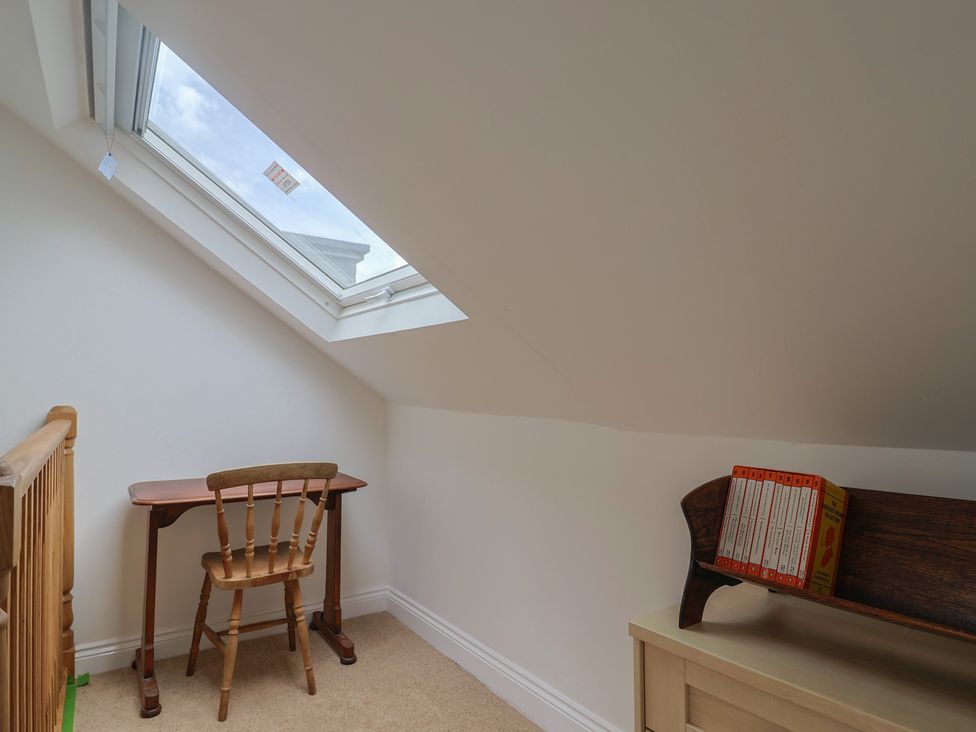 An attic space with a desk and chair at Saybrook Cottage in Charmouth