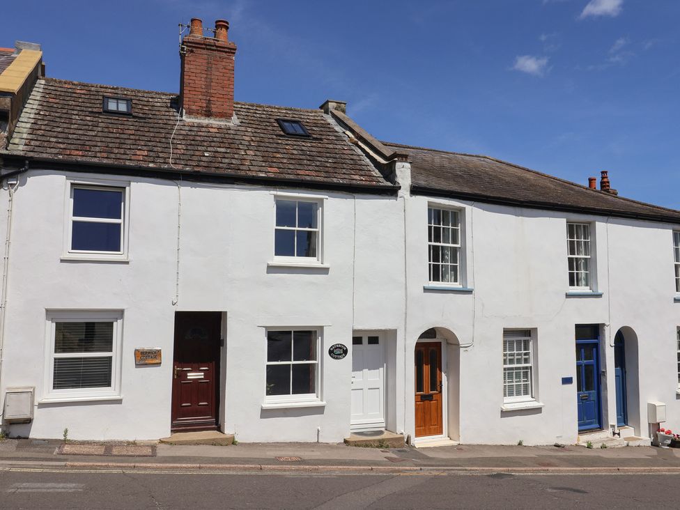 A row of houses with different colored doors at Saybrook Cottage in Charmouth