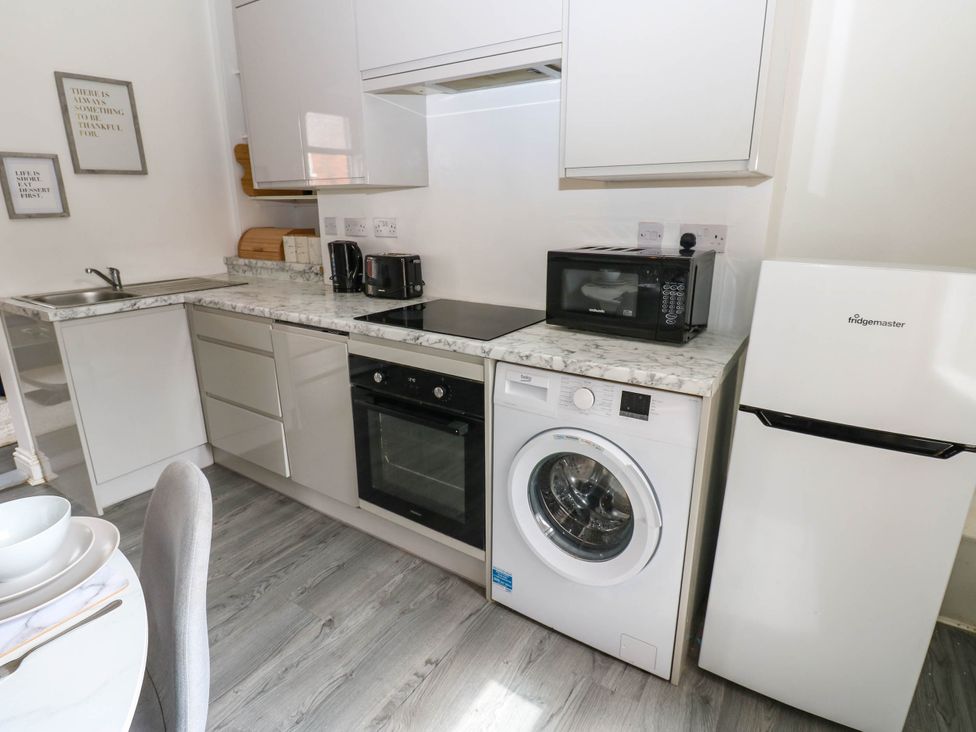 A kitchen with appliances including a washing machine and microwave at 22 Prospect Terrace Brancepeth