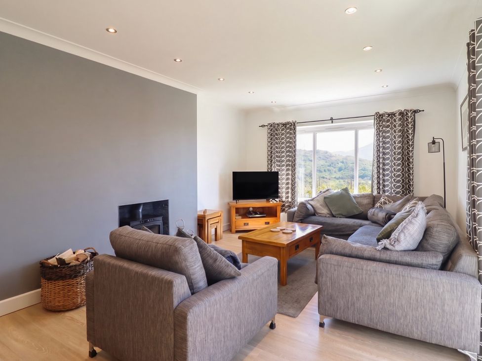A living room with a coffee table and television at Tyn Y Weirglodd in Deiniolen