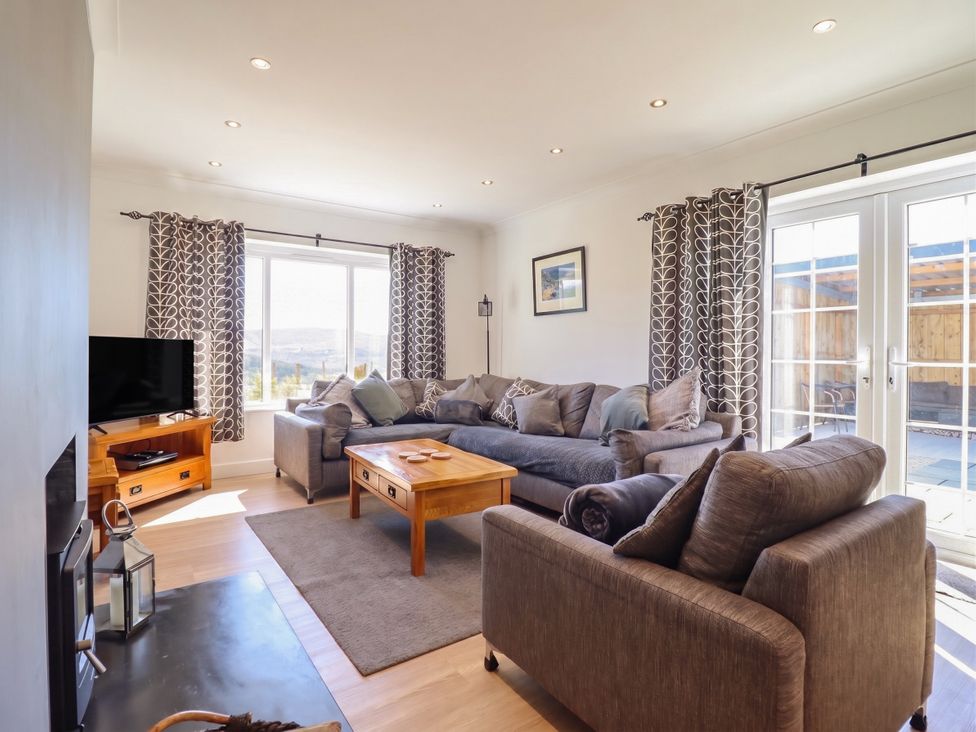 A living room with a sofa and coffee table at Tyn Y Weirglodd in Deiniolen