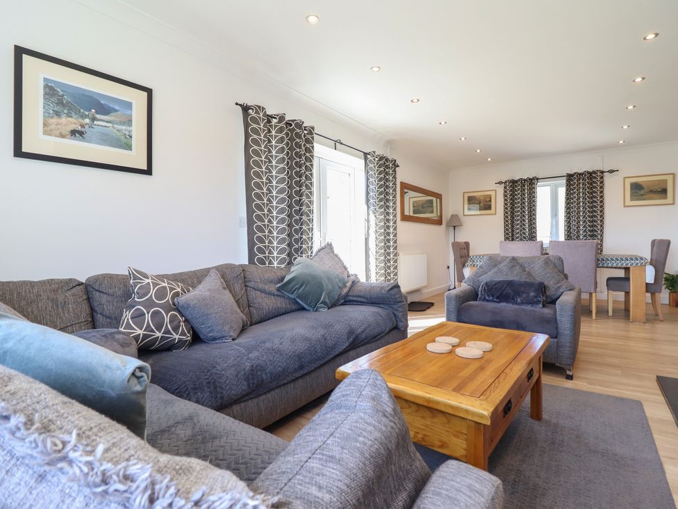 A living room with a sofa and table at Tyn Y Weirglodd in Deiniolen