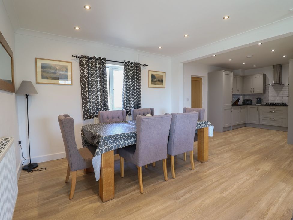 A dining room with a table and chairs at Tyn Y Weirglodd in Deiniolen