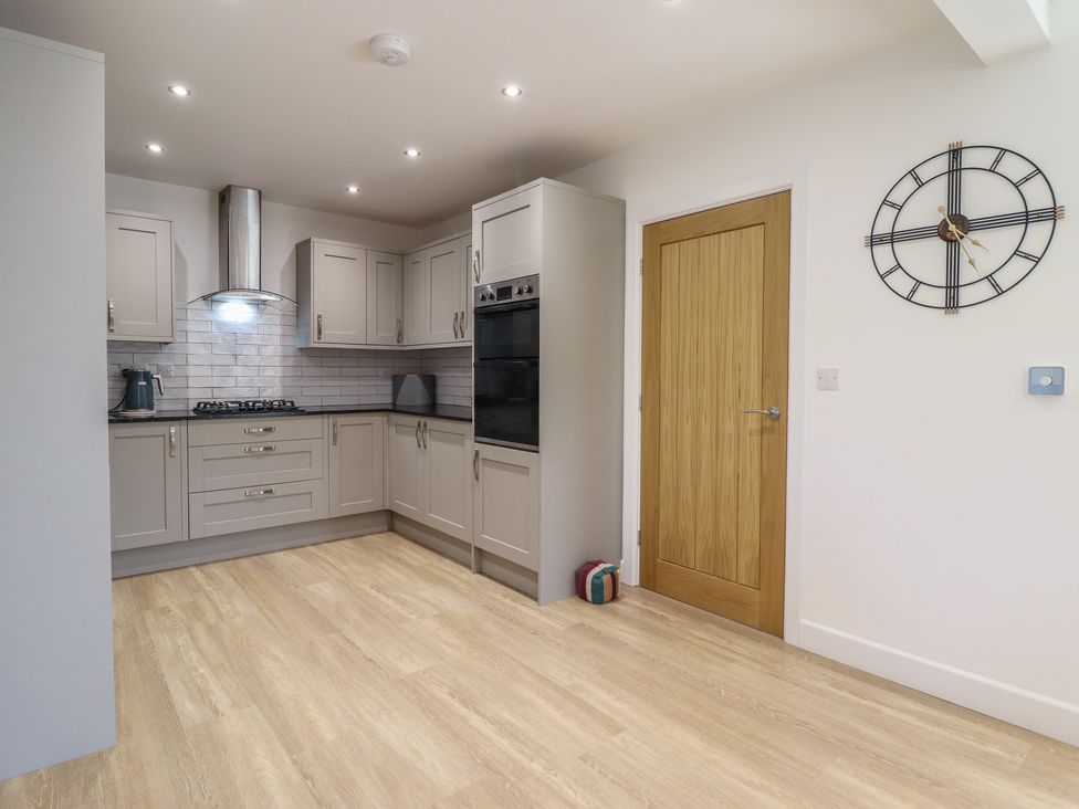 A kitchen with cabinets and appliances at Tyn Y Weirglodd in Deiniolen