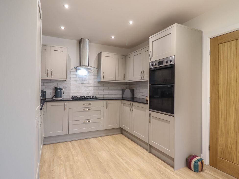 A kitchen with cabinets and appliances at Tyn Y Weirglodd in Deiniolen