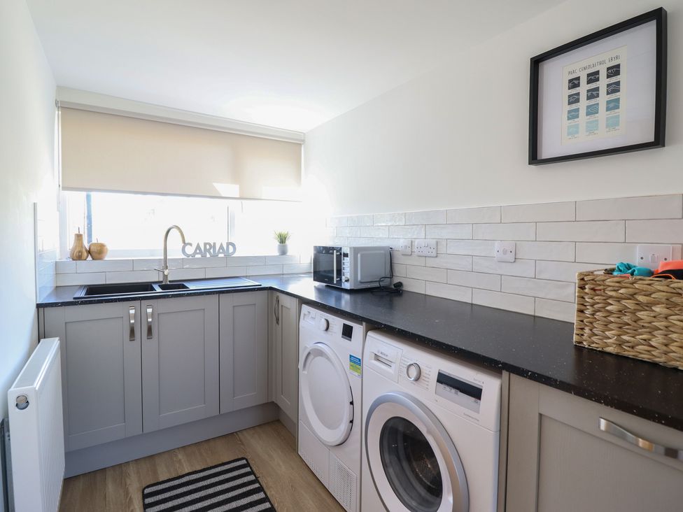A laundry room with a washing machine and dryer at Tyn Y Weirglodd in Deiniolen