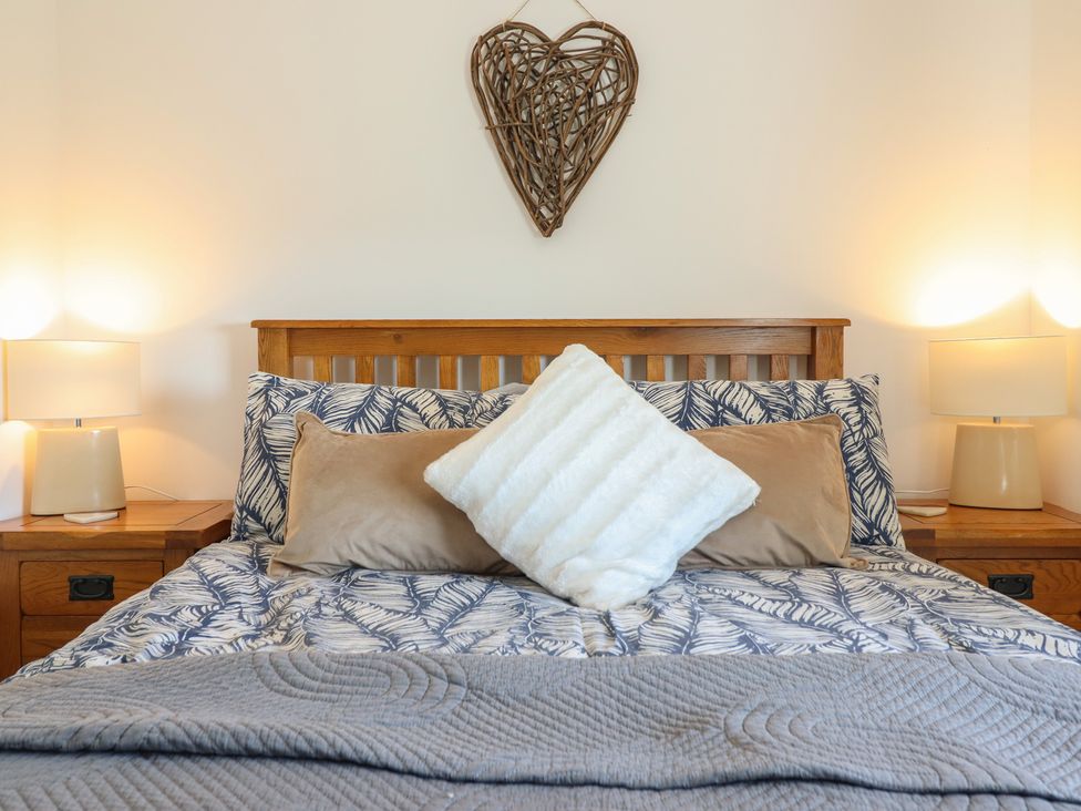A bedroom with a bed and lamps at Tyn Y Weirglodd in Deiniolen