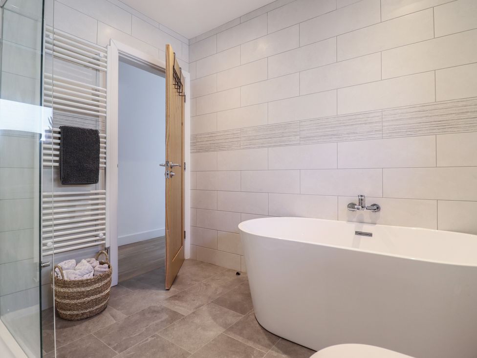 A bathroom with a bathtub and towel radiator at Tyn Y Weirglodd in Deiniolen