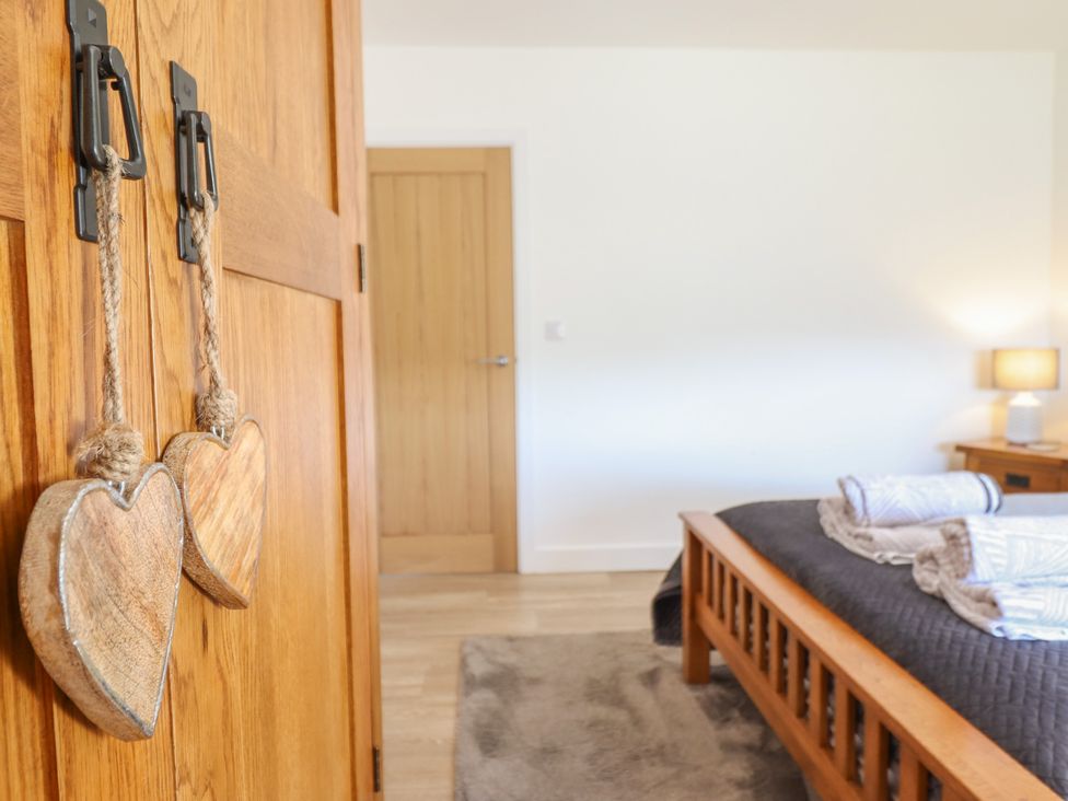 A bedroom with wooden furniture and heart decorations at Tyn Y Weirglodd in Deiniolen