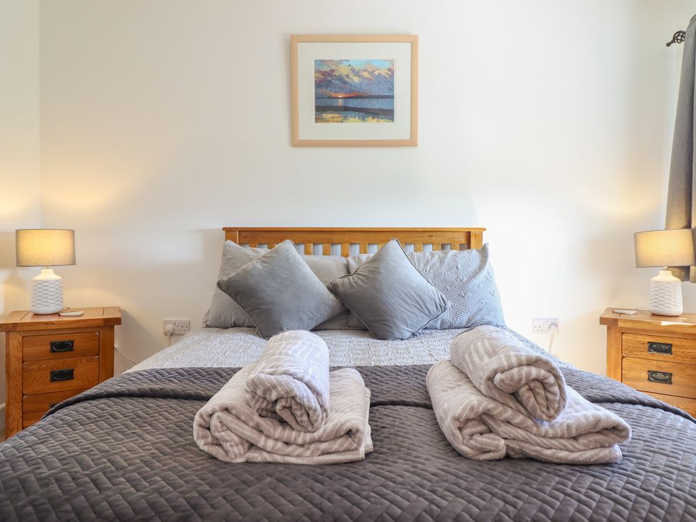 A bedroom with a bed and lamps at Tyn Y Weirglodd in Deiniolen