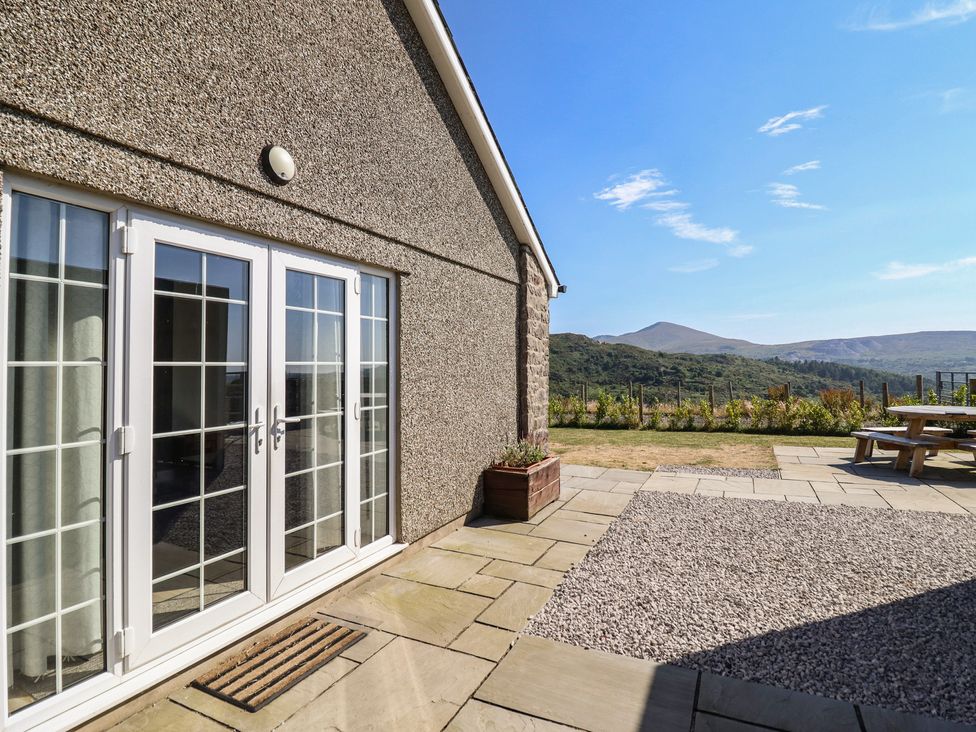 An outdoor area with double doors and mountains at Tyn Y Weirglodd in Deiniolen