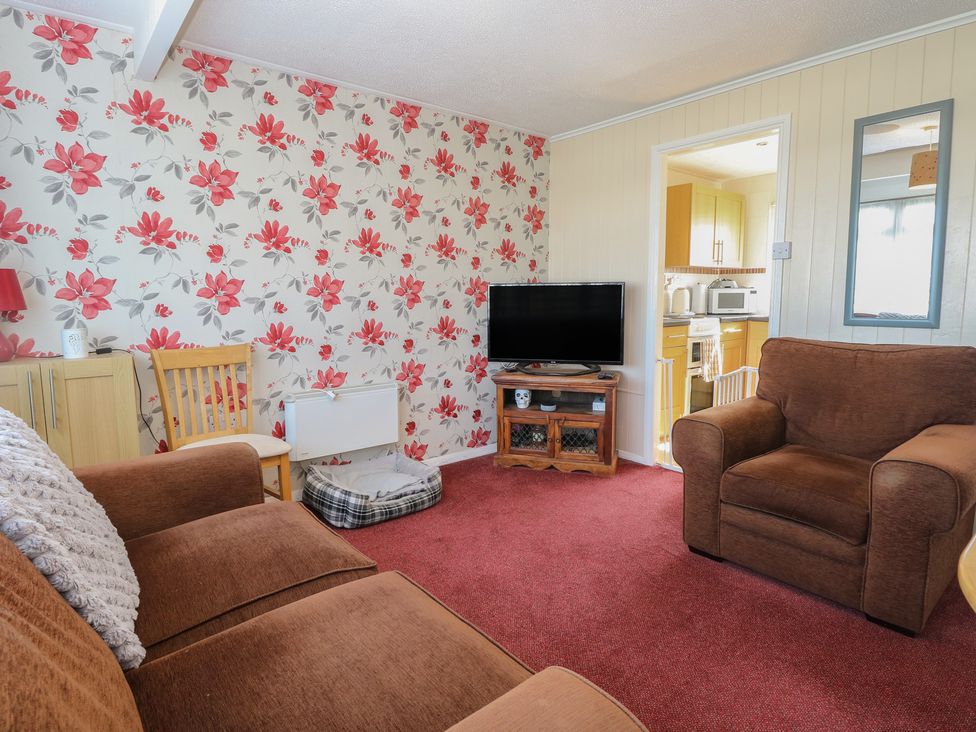 A living room with a sofa and TV at Mon Chalet in Hemsby
