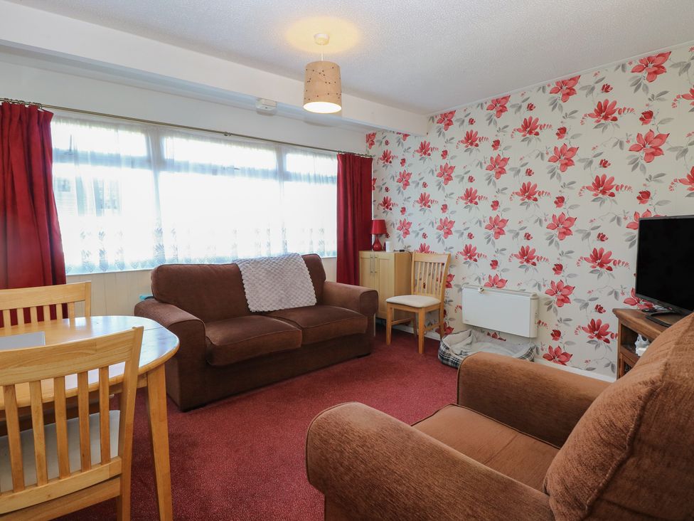 A living room with sofa and dining table at Mon Chalet in Hemsby