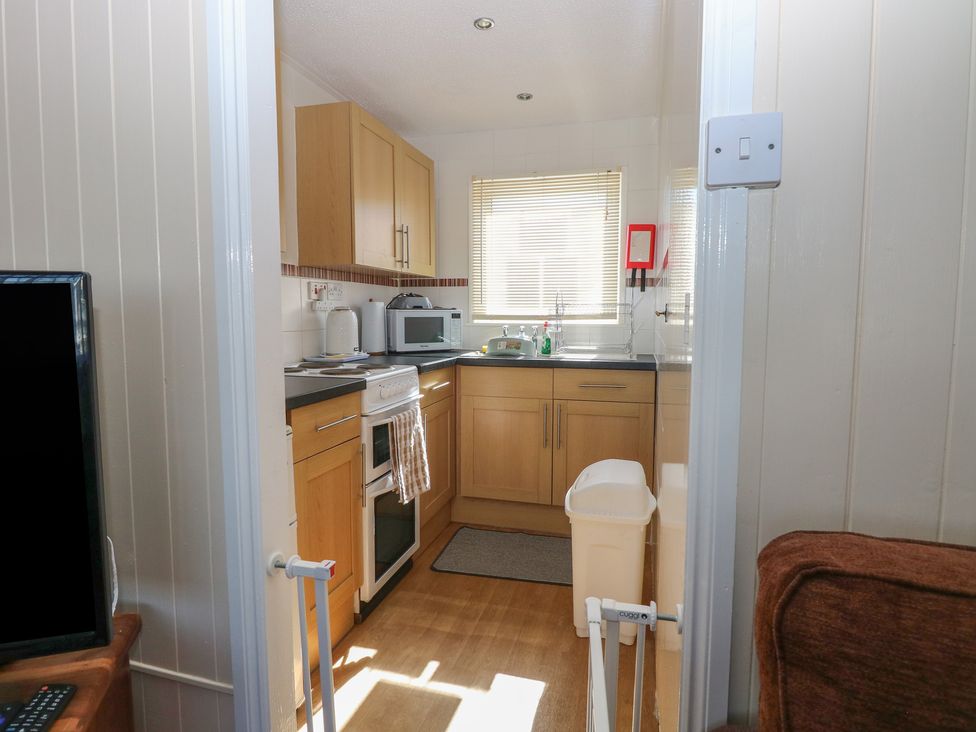 A kitchen with appliances and cabinets at Mon Chalet in Hemsby