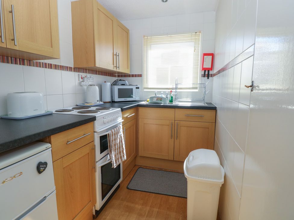 A kitchen with cabinets and appliances at Mon Chalet in Hemsby