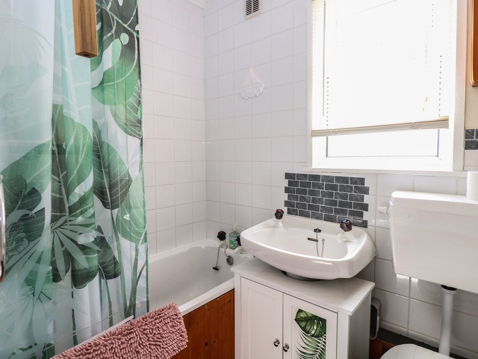 A bathroom with a bathtub and sink at Mon Chalet in Hemsby