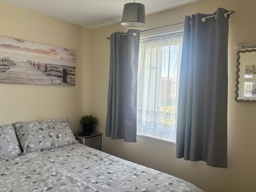 A bedroom with a bed and window at Mon Chalet Hemsby