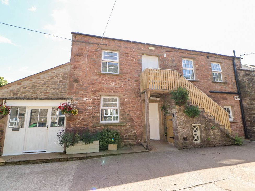An outdoor view of a building with stairs and windows at Dairy Cottage in Kirkby Stephen