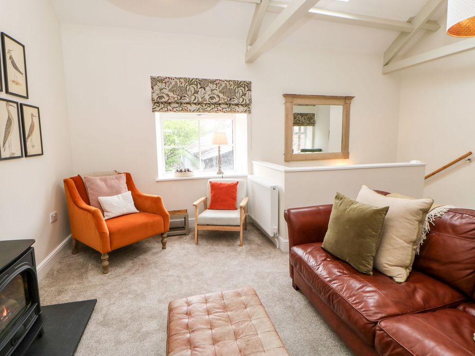 A living room with a sofa and armchair at Dairy Cottage in Kirkby Stephen