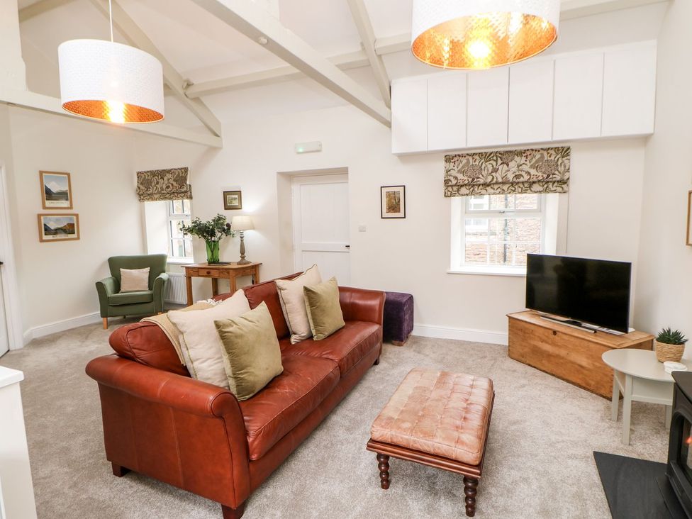 A living room with a sofa and television at Dairy Cottage in Kirkby Stephen