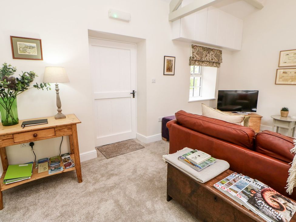 A living room with a sofa and television at Dairy Cottage in Kirkby Stephen