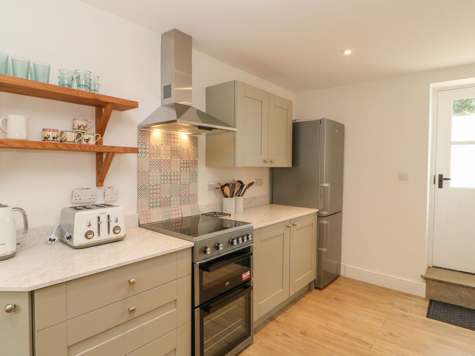 A kitchen with a stove and a refrigerator at Dairy Cottage in Kirkby Stephen
