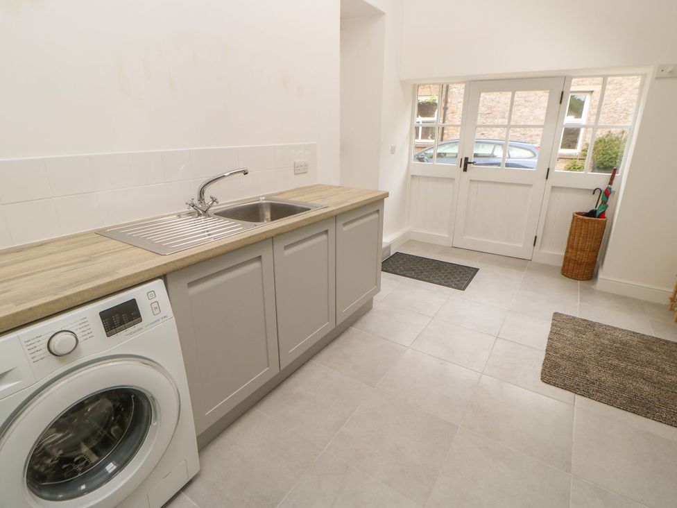 A laundry room with a washing machine and sink at Dairy Cottage in Kirkby Stephen