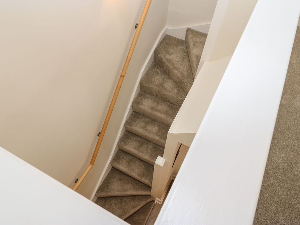 A staircase with carpet and a handrail at Dairy Cottage in Kirkby Stephen
