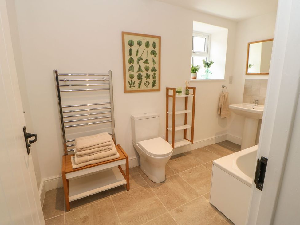 A bathroom with a toilet, sink, and bathtub at Dairy Cottage in Kirkby Stephen