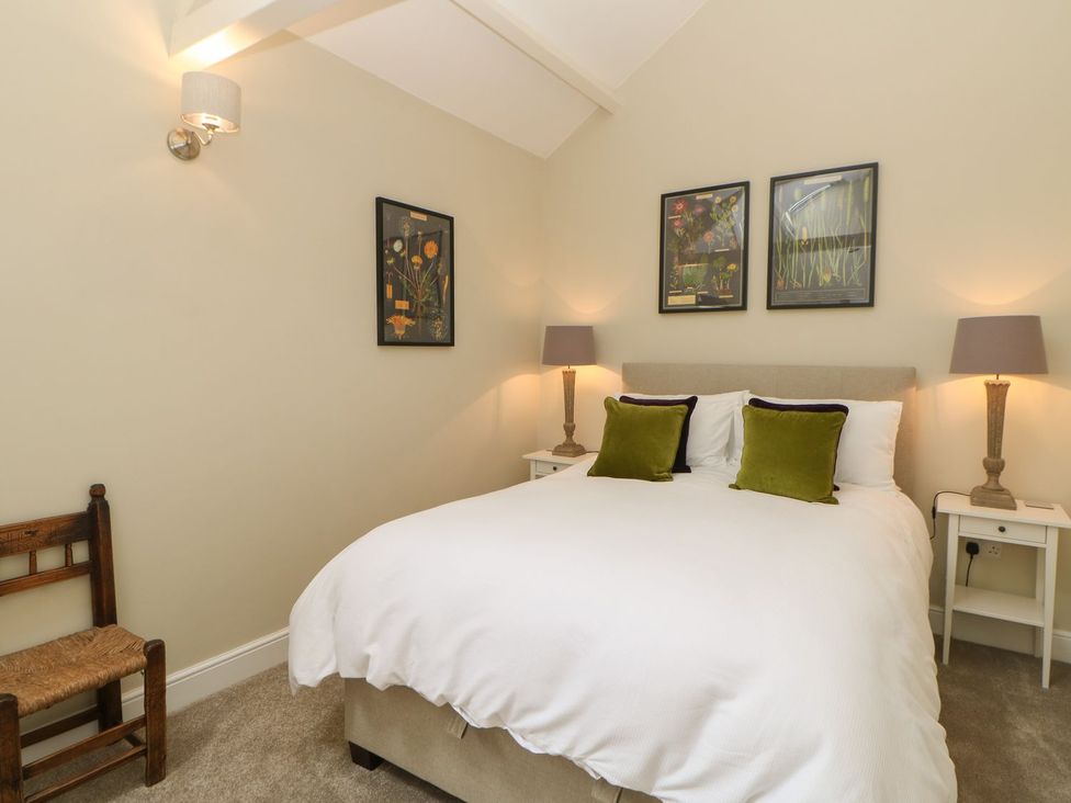 A bedroom with a bed and wall art at Dairy Cottage in Kirkby Stephen