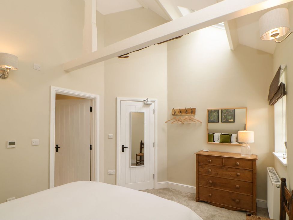 A bedroom with a dresser and mirror at Dairy Cottage in Kirkby Stephen