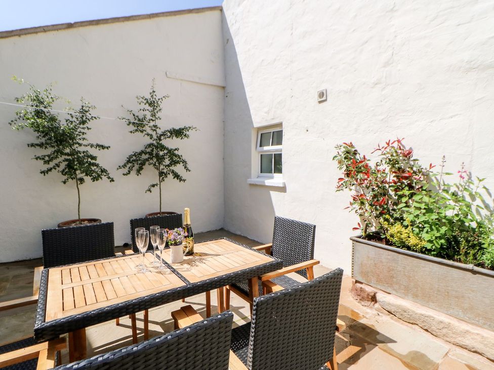 An outdoor area with a table and chairs at Dairy Cottage in Kirkby Stephen