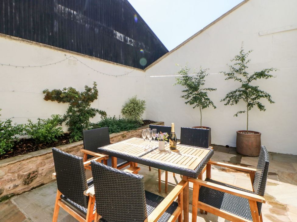 An outdoor seating area with a table and chairs at Dairy Cottage in Kirkby Stephen