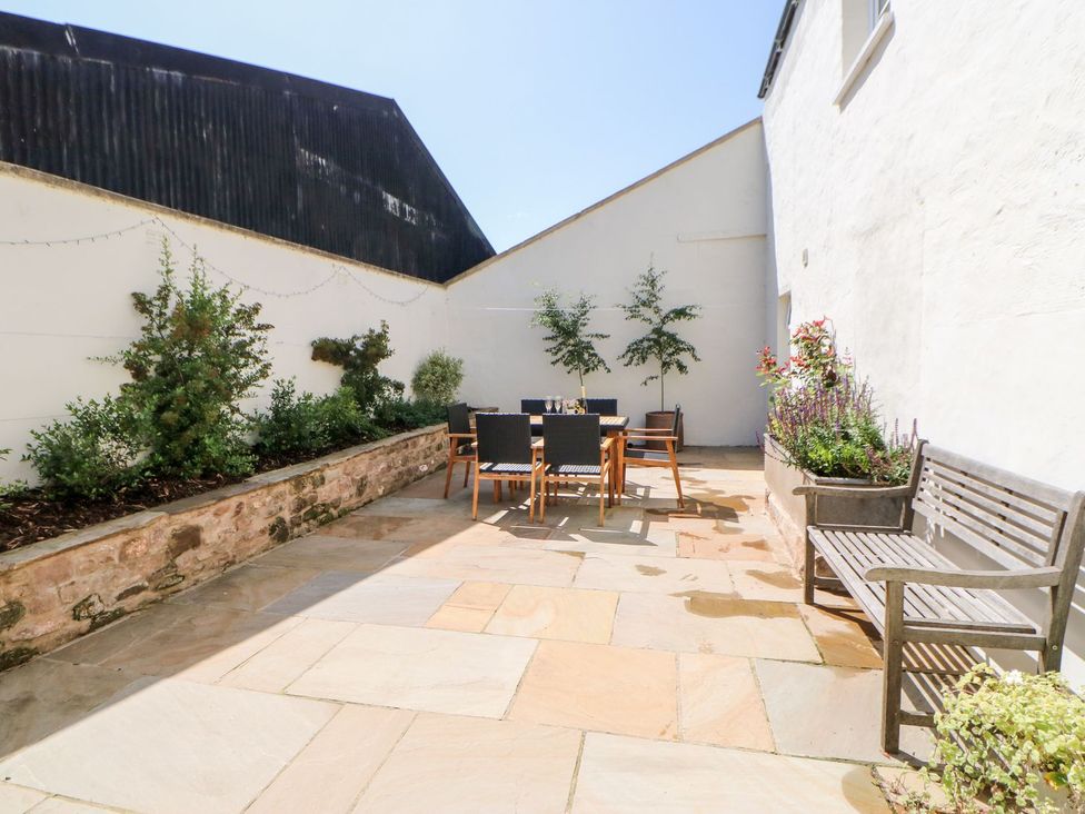 A patio area with a table and chairs at Dairy Cottage in Kirkby Stephen